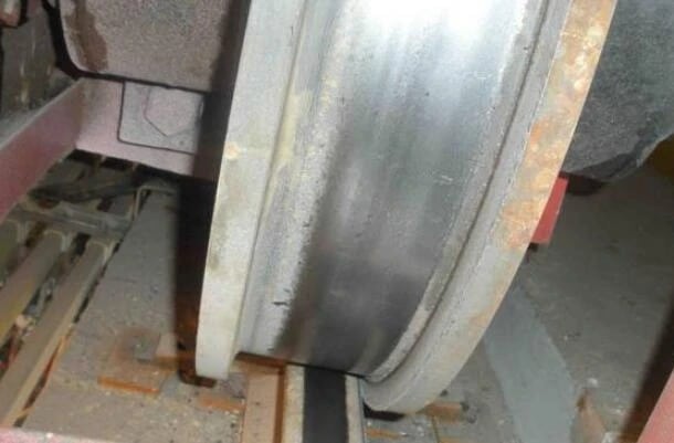 Close up of a severely worn crane wheel flange caused by rail misalignment