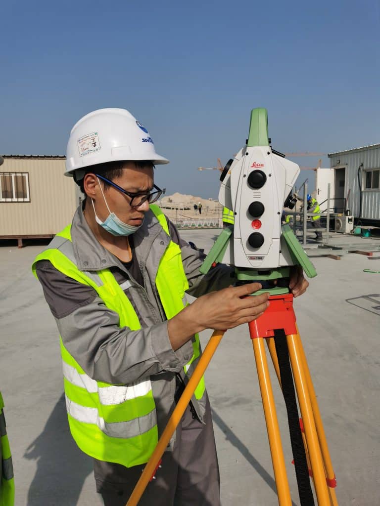 Engineer uses total station to mark rail runway centerline during Heavy-Duty Crane Rail Installation Best Practices at construction site